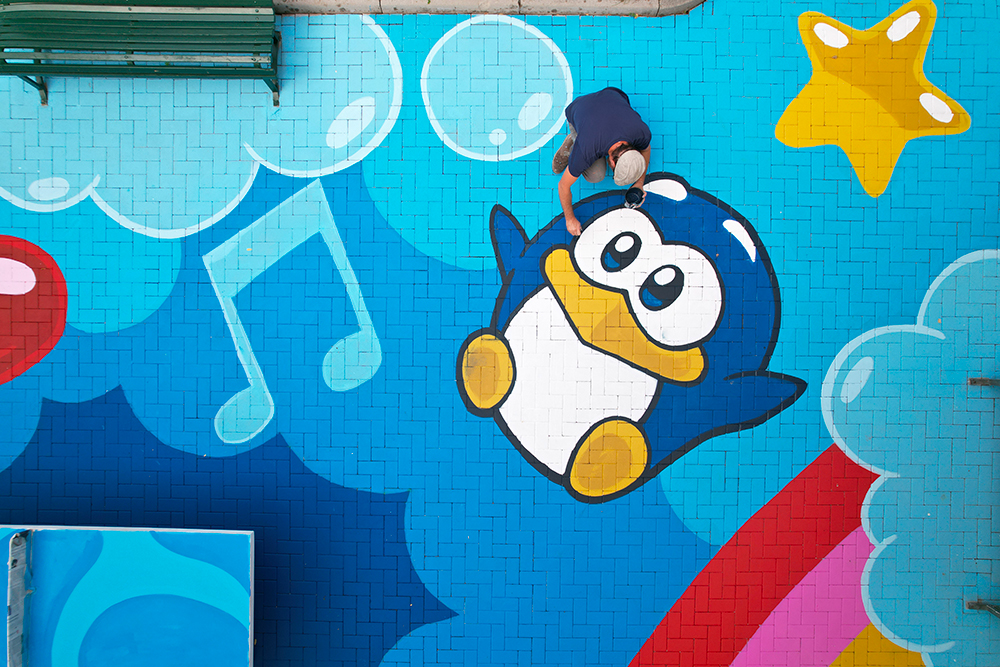 pinguino gigante nalla Piazza dipinta da PAO a tema candyland