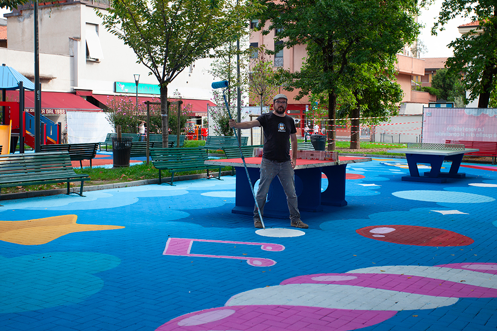 PAO mentre dipinge il floor painting colorato di Piazza Belloveso a Milano per il progetto HARIBO Happyland, street art urbana tra gioco e fantasia