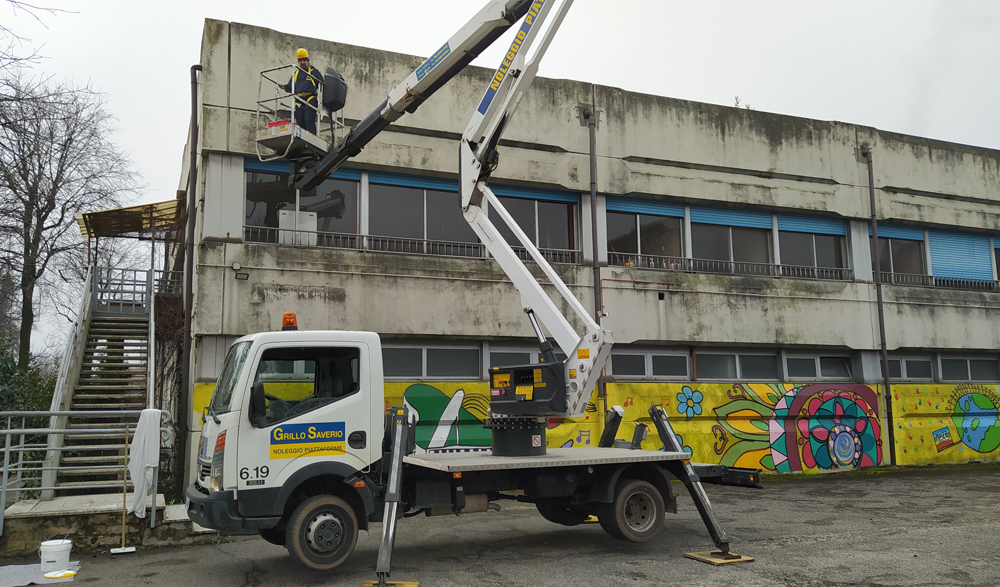 Pao su piattaforma aerea pulisce la superficie ammalorata della scuola in via Sapri