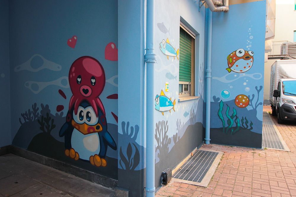 polpo innamorato del pinguino di PAO e riccio di mare  disegnati da pao sul muro del nuovo atrio dell'ospedale gaslini di genova nel 2025